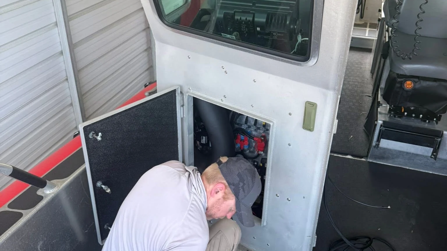 MTAG technician performing FLIR and networked C2 integration inside a small craft electronics bay